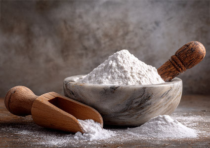 Marble bowl filled with DLPA white powder on a wooden surface with wooden scoops.