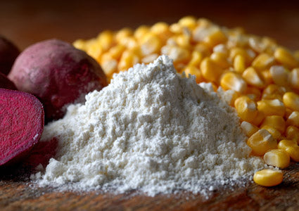 L-Arginine white powder on a wooden surface with corn kernels and red potatoes in the background