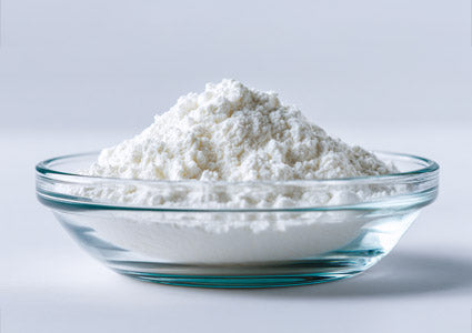 L-Phenylalanine in a glass bowl filled with white powder on a light gray background