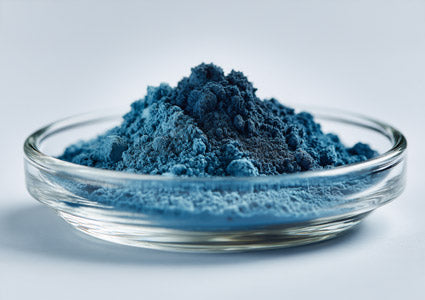 Vanadyl Sulfate Blue powder in a glass bowl on a light gray background