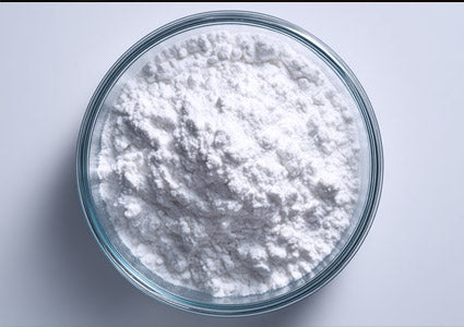 Leucine white powdery substance in a glass bowl on a light gray background