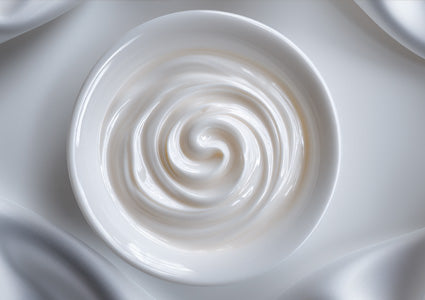 Close-up of a swirl of Vitamin B white cream on a white background